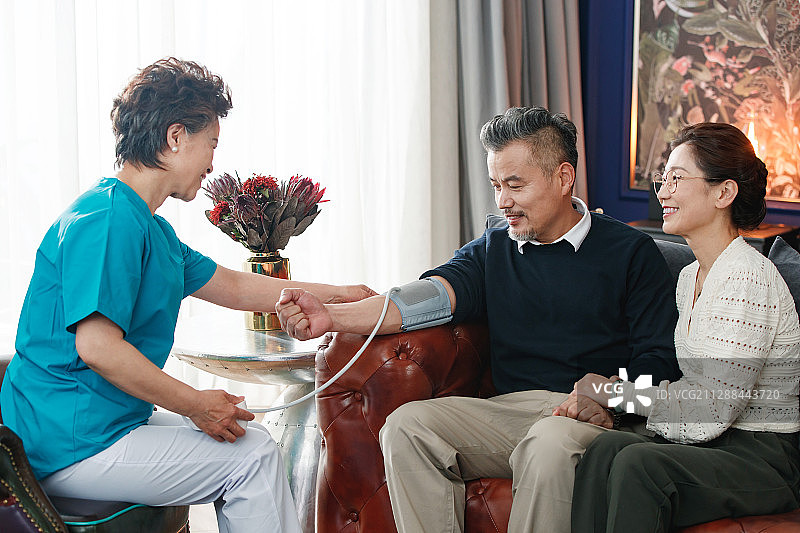 护理人员给中老年人量血压图片素材