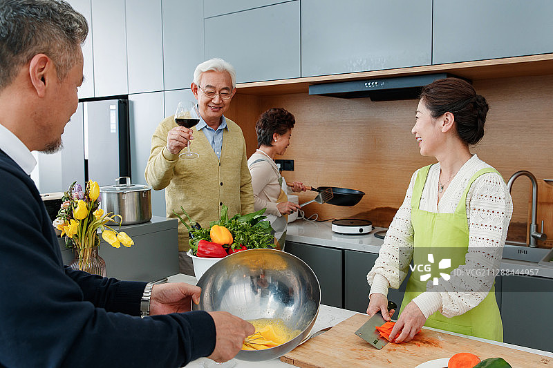 快乐的中老年人在厨房做饭图片素材