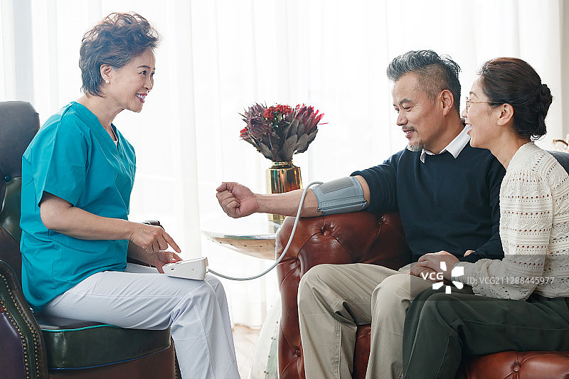 护理人员给中老年人量血压图片素材