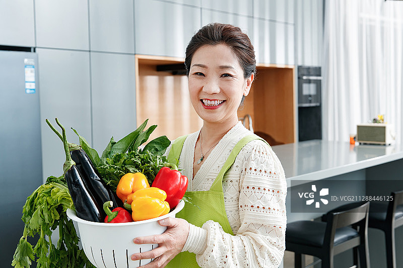 拿着一筐蔬菜的中老年女士图片素材