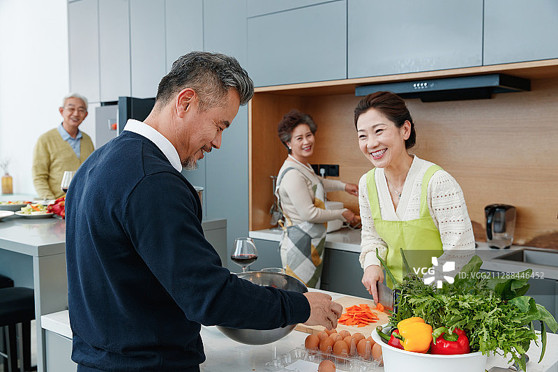 快乐的中老年人在厨房做饭图片素材