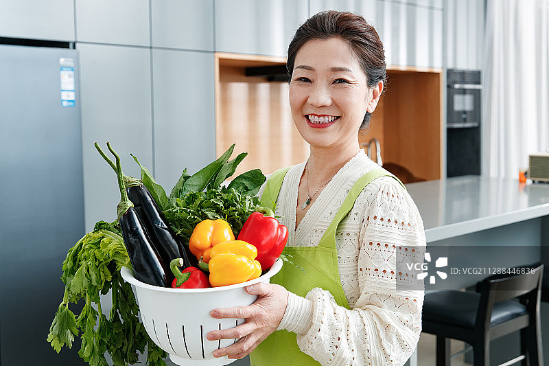 拿着一筐蔬菜的中老年女士图片素材