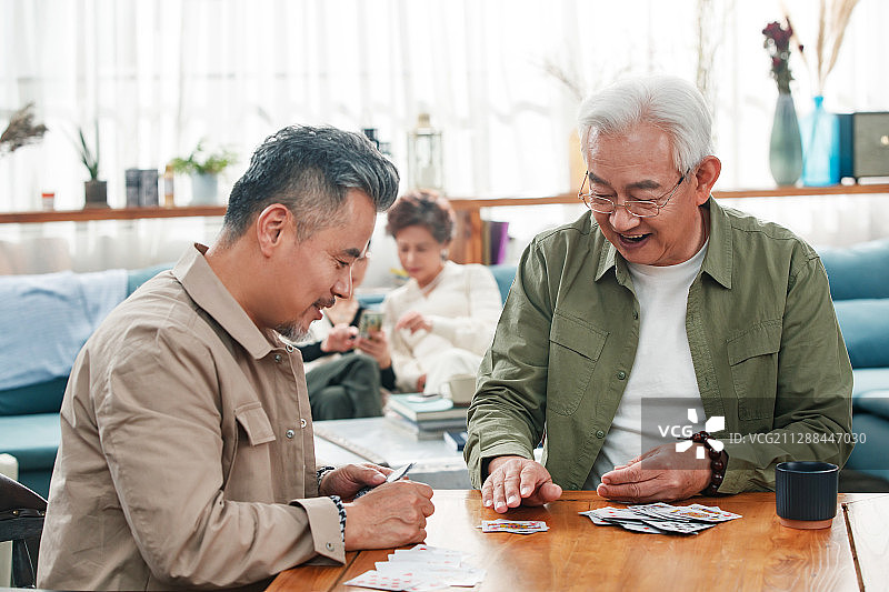 快乐的老朋友玩扑克牌图片素材