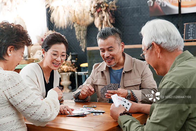 快乐的老朋友玩扑克牌图片素材