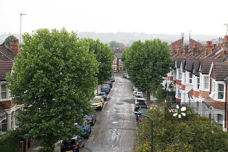 伦敦绿树成荫的街道上的维多利亚式房屋和汽车图片素材