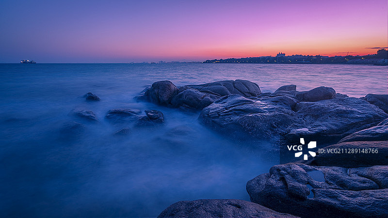 北戴河海滨落日余晖映照下的大海与礁石图片素材