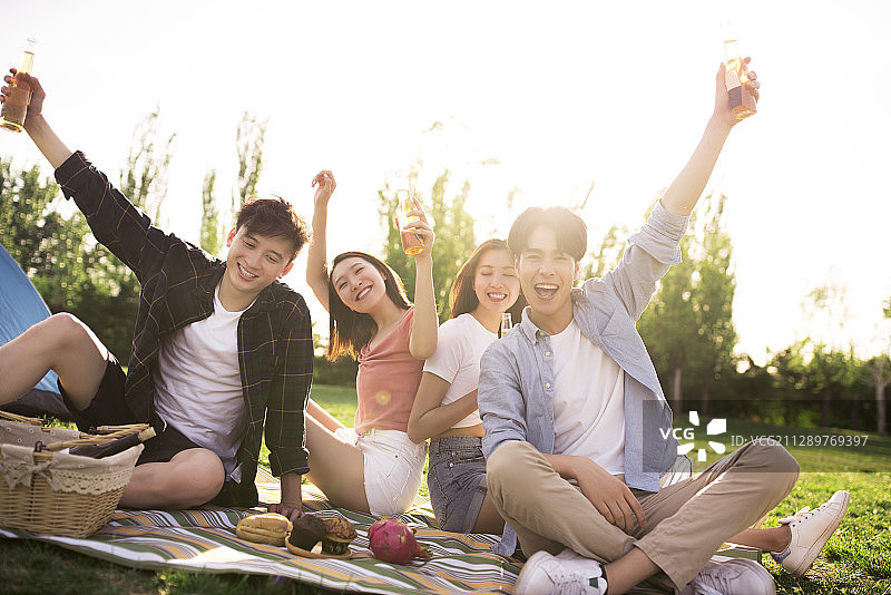 快乐的年轻朋友在户外野餐聚会图片素材