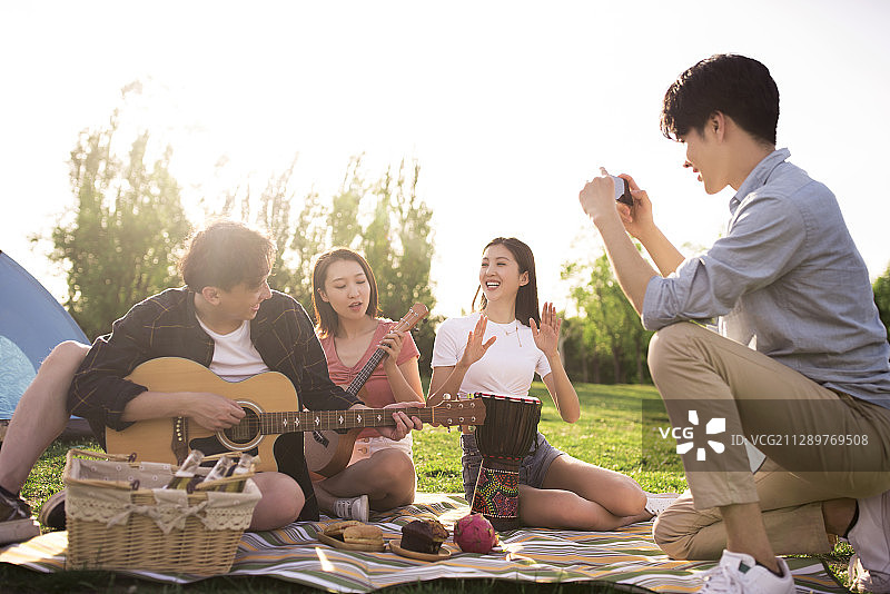年轻朋友在户外野餐用手机拍照图片素材