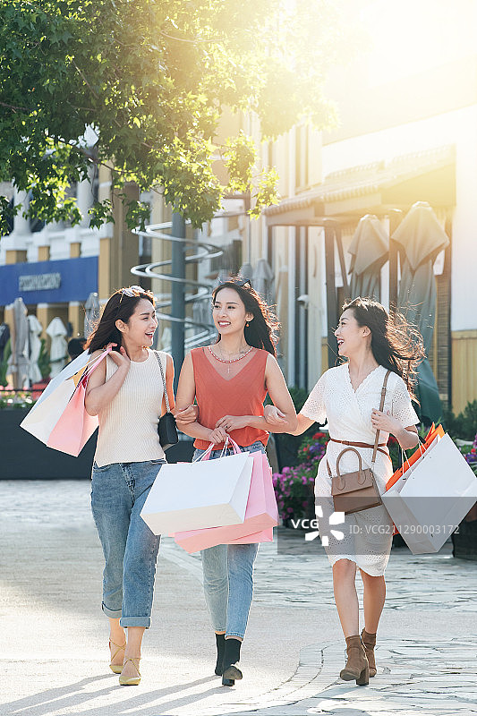 阳光下快乐逛街的年轻女孩们图片素材
