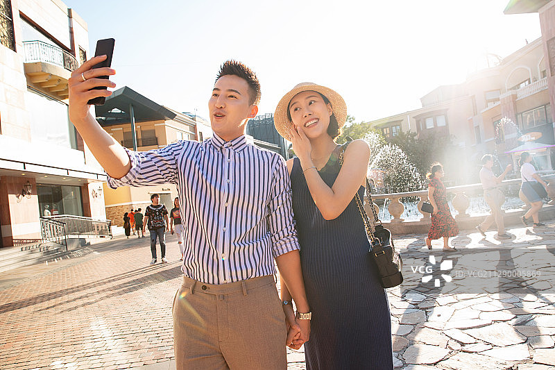 丈夫和怀孕的妻子看手机图片素材