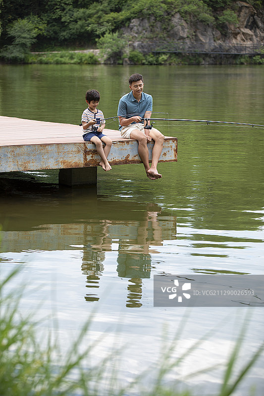 快乐父子在河边钓鱼图片素材