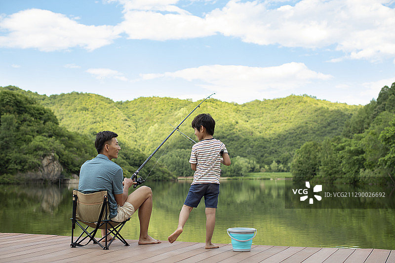 快乐父子在河边钓鱼图片素材