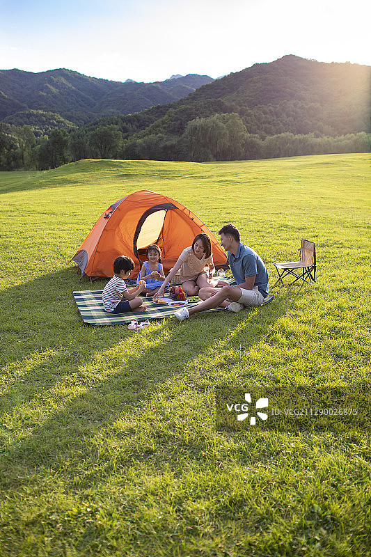 快乐的年轻家庭在户外野餐图片素材