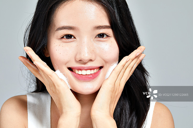 使用洗面奶洗脸的微笑美女图片素材