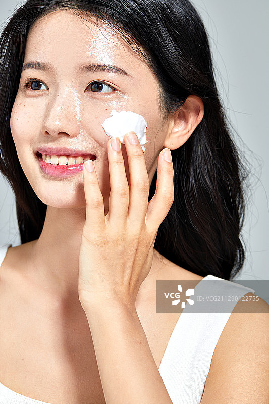 使用洗面奶洗脸的微笑美女图片素材