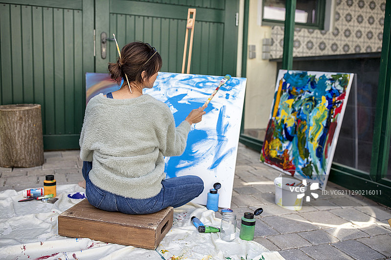女子在院子里绘画的背影图片素材