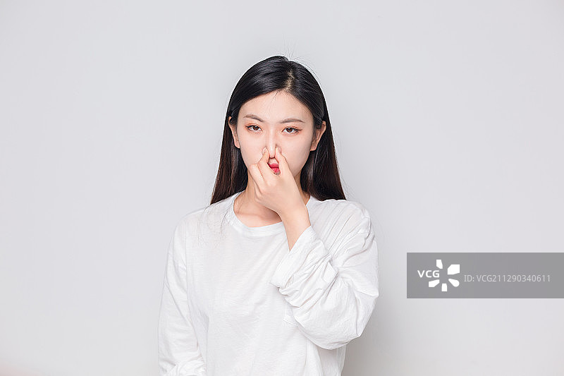 在房间里，闻到臭味的亚洲美女图片素材