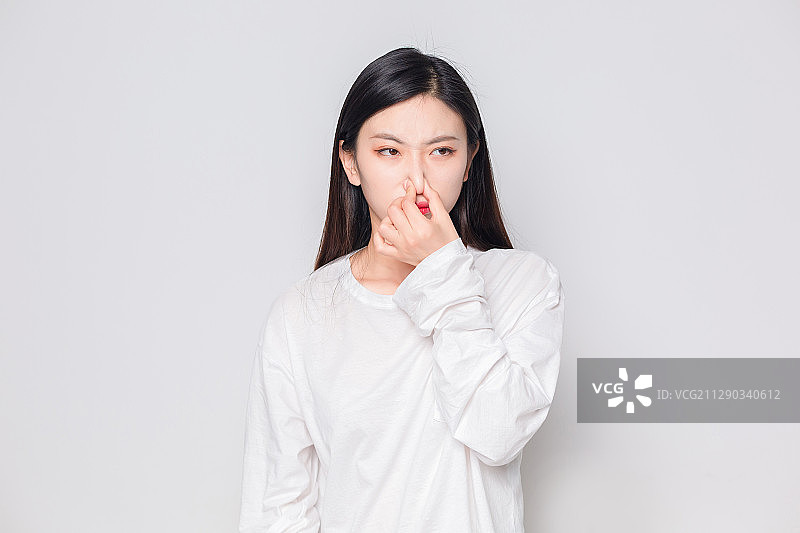 在房间里，闻到臭味的亚洲美女图片素材