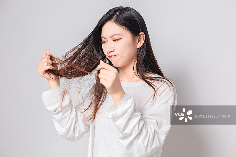 亚洲美女看到自己头发分叉，感到很难过图片素材