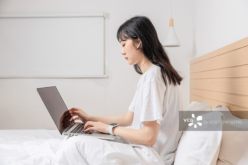 躺在床上上网的清纯女孩图片素材