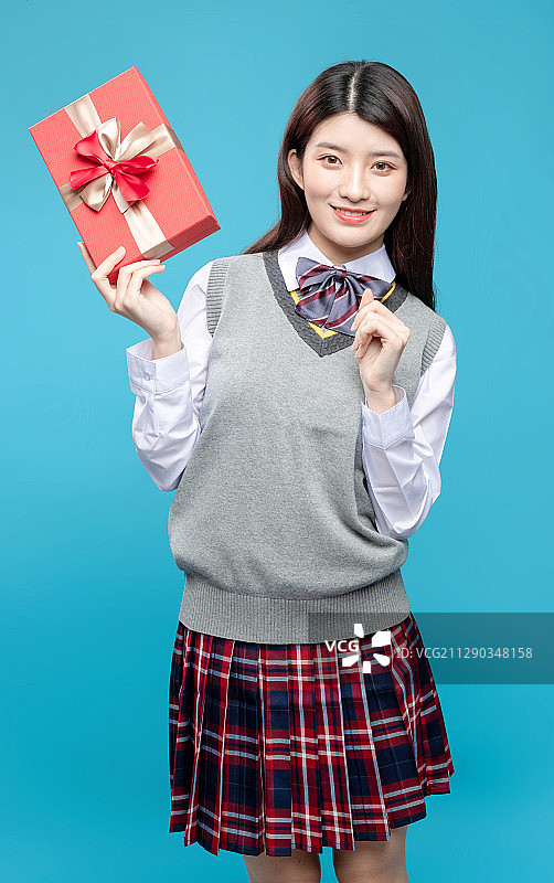蓝色背景里拿着礼物的中国女学生图片素材