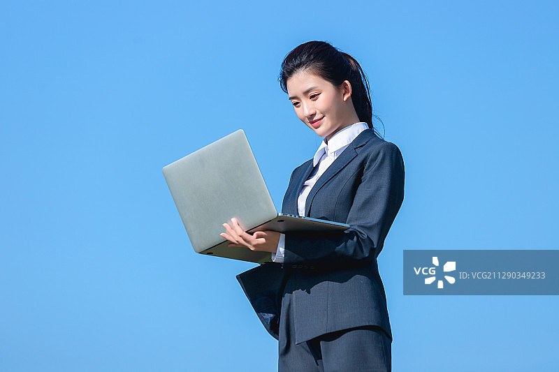 蓝色天空里的美丽商务女士图片素材