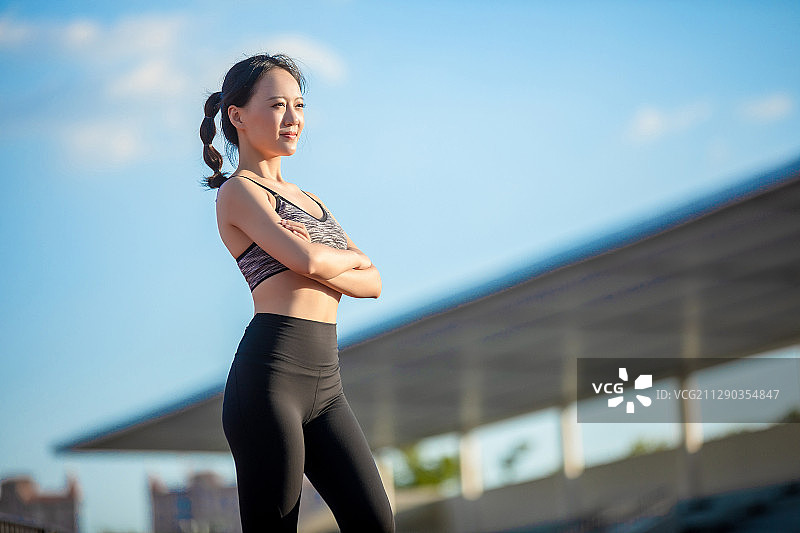 户外体育场里，正在做热身运动的亚洲女孩图片素材