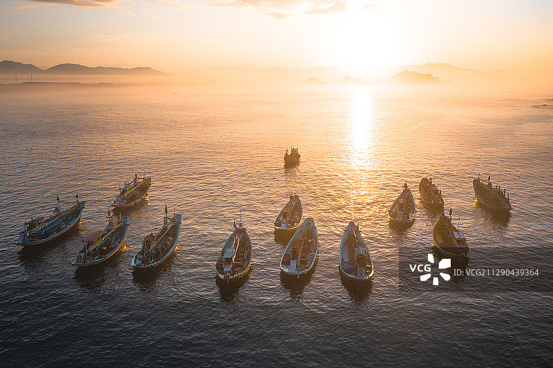 日出时航拍海岛和海岸线上停靠的渔船图片素材