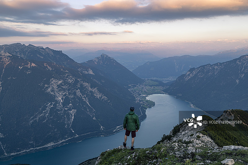 徒步者在欧洲山顶俯瞰湖泊图片素材