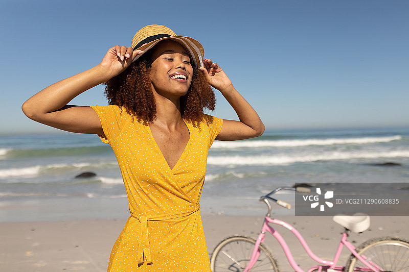混血女人在海滩上骑自行车图片素材