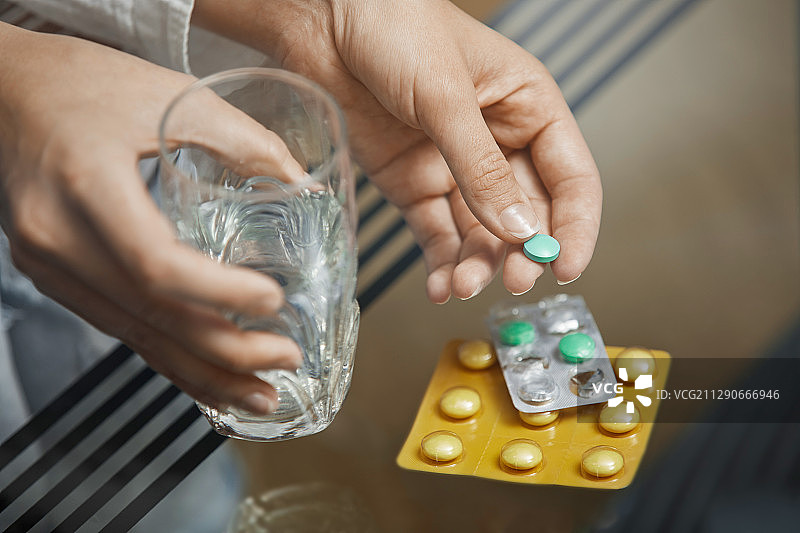 拿着水杯和药片的女人图片素材