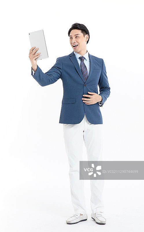 穿蓝色西装的年轻男性使用平板电脑图片素材