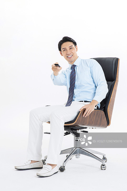 使用遥控器的年轻商务男士图片素材