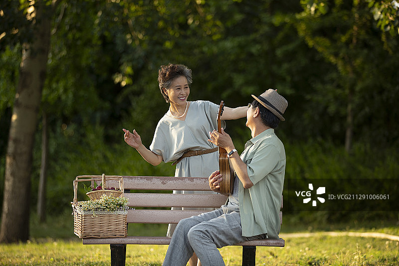 老年伴侣在户外弹琴和跳舞图片素材