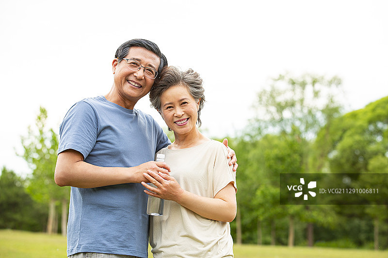 老年夫妻拿着水瓶在户外公园运动后图片素材