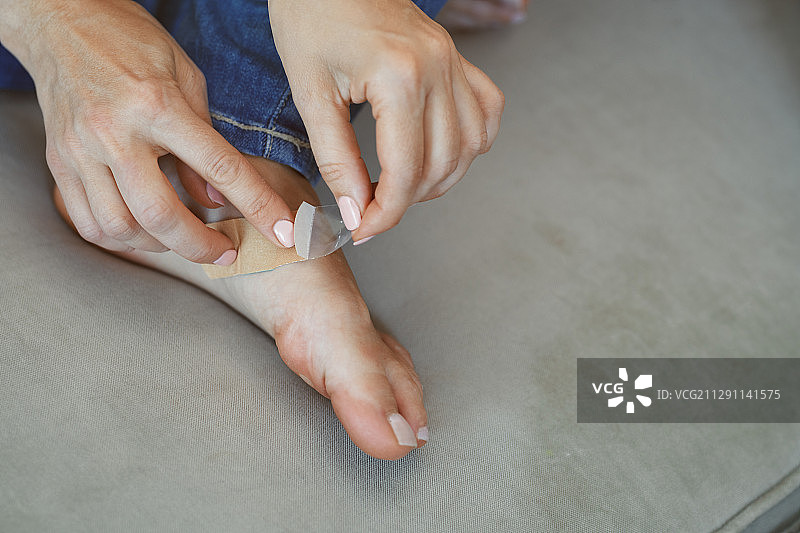 女人在受伤的脚上贴上胶带图片素材