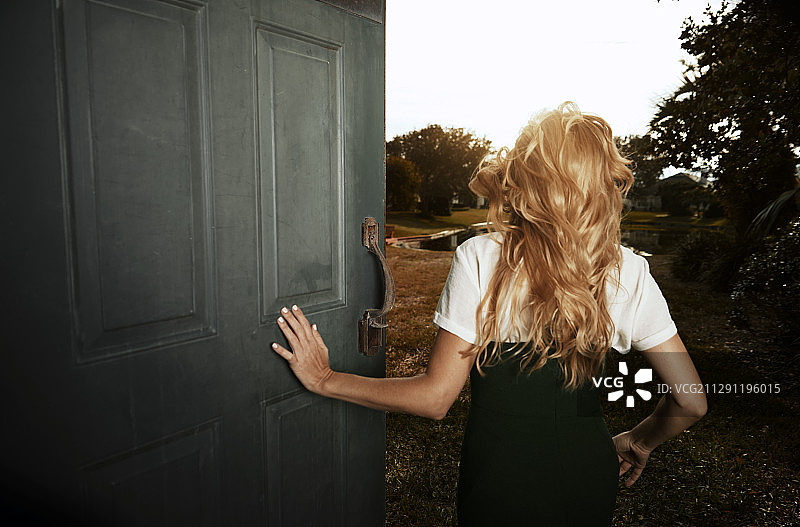 快乐的女人在敞开的门旁跑步，适合做书籍封面图片素材