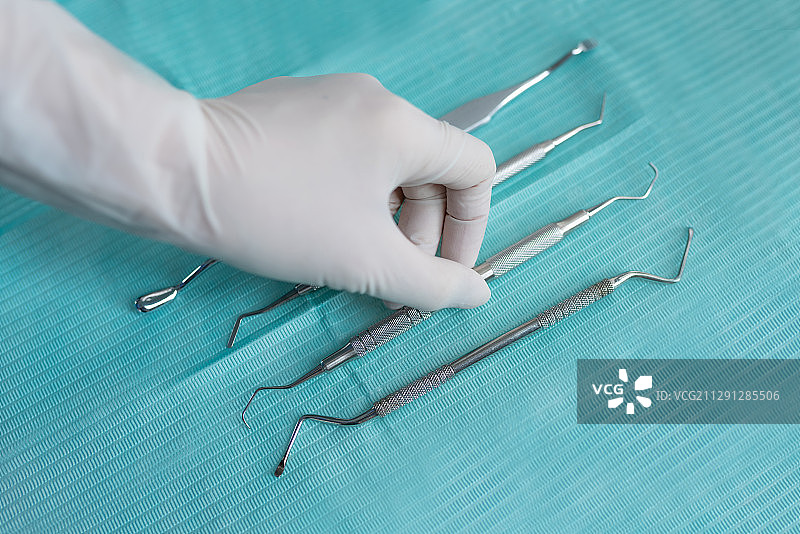 牙医带白手套拿医疗器械图片素材