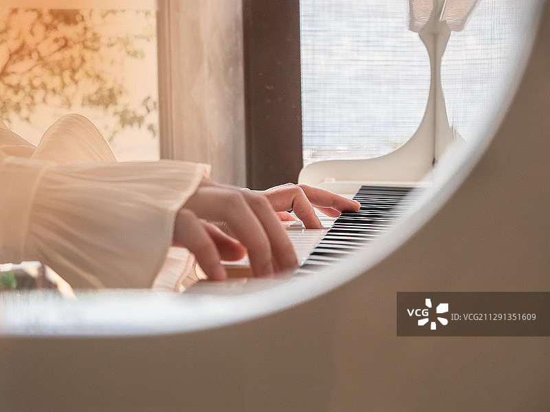 在一个阳光的下午女孩正在弹钢琴图片素材