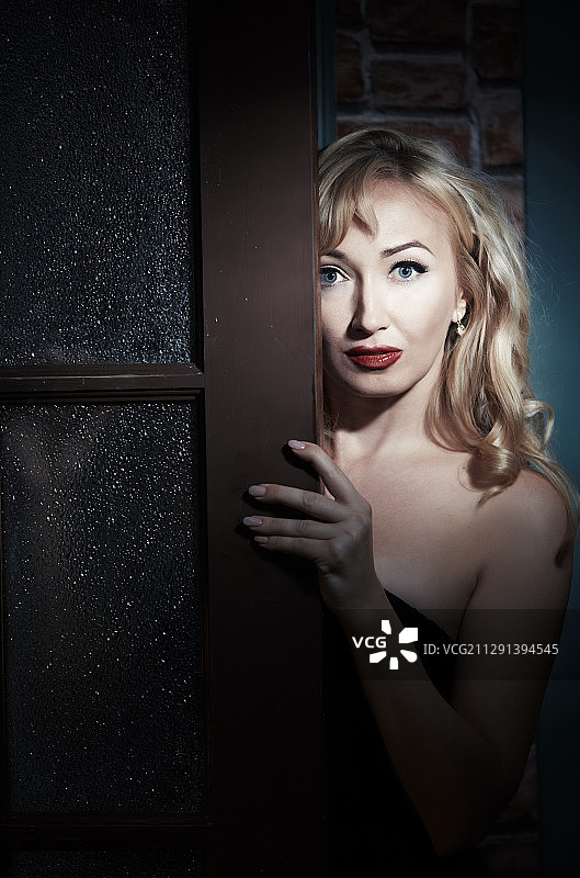 害怕的女人躲在门后图片素材