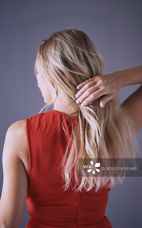 触摸头发的金发女子背影图片素材