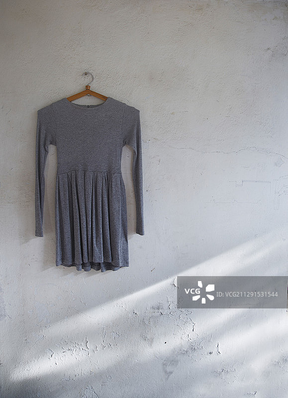 挂在破损墙壁上的复古连衣裙图片素材