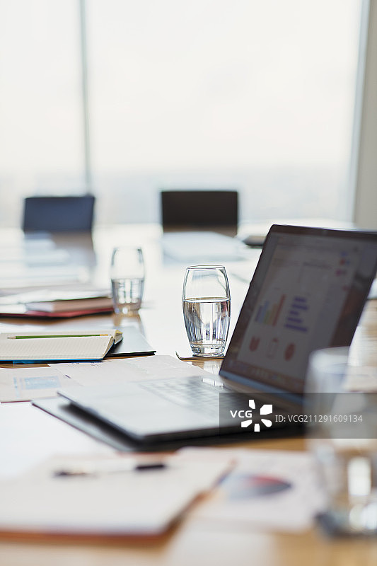 会议室桌子上的笔记本电脑和文书工作图片素材