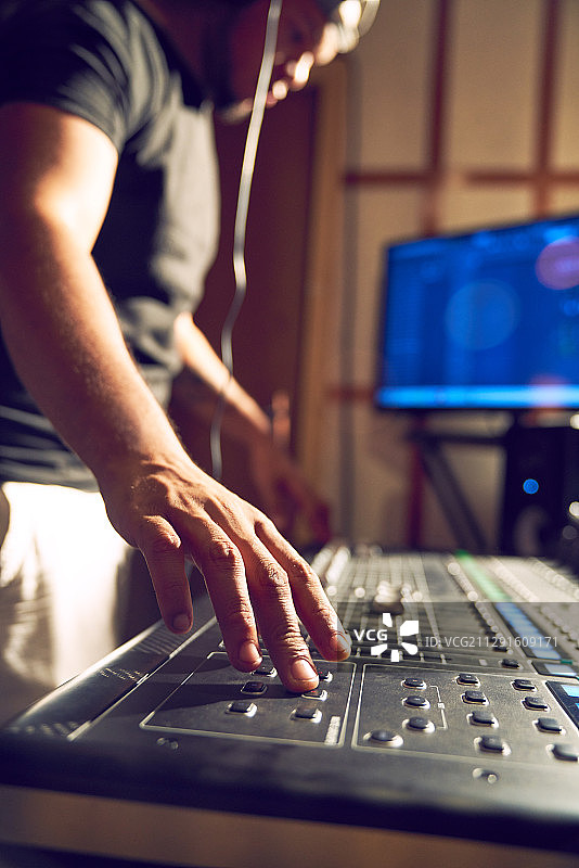 在录音室的调音台工作的男人图片素材