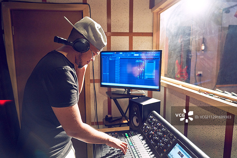 在录音室的调音台上工作的音乐制作人图片素材