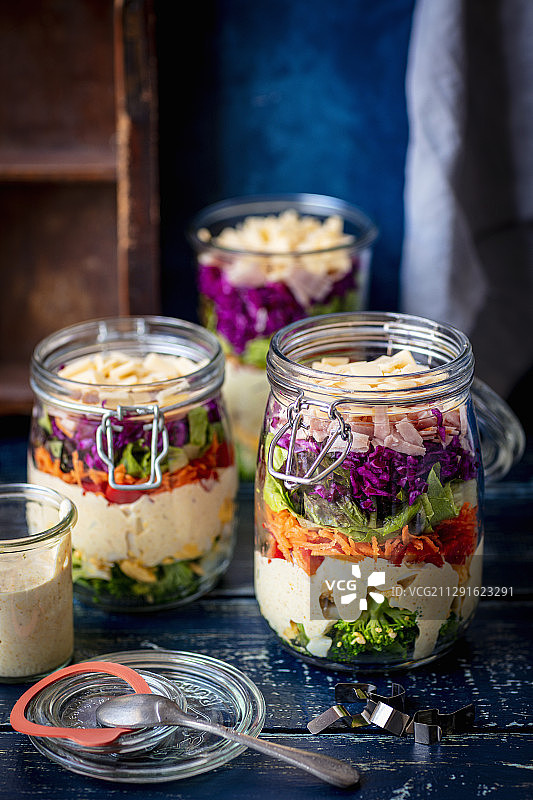 罐装分层沙拉——西兰花、鸡蛋、酱汁、胡椒、胡萝卜、生菜、紫甘蓝、火腿、奶酪图片素材