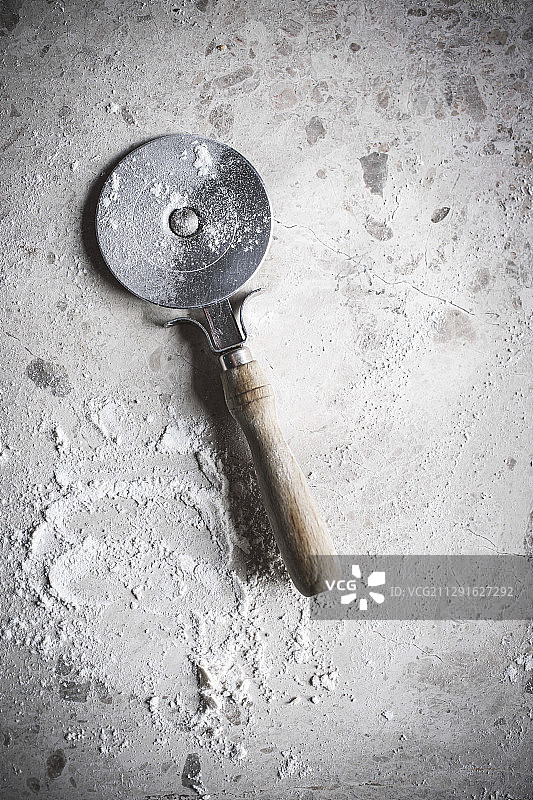 石面上的披萨刀和面粉图片素材