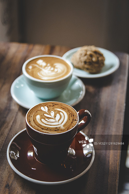 彩色杯子里的卡布奇诺咖啡和饼干图片素材