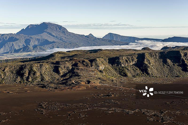 在通往富尔奈斯火山的道路后方升起的内日峰火山，留尼汪，非洲图片素材