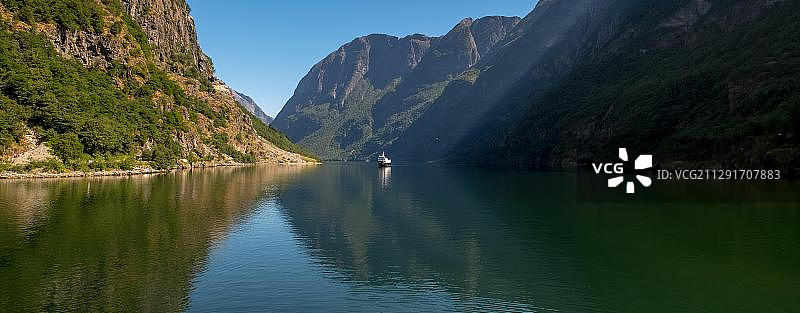 挪威奥兰峡湾岩壁之间的游览船图片素材